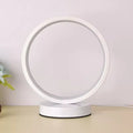Round white lamp on a beige surface with a light purple background
